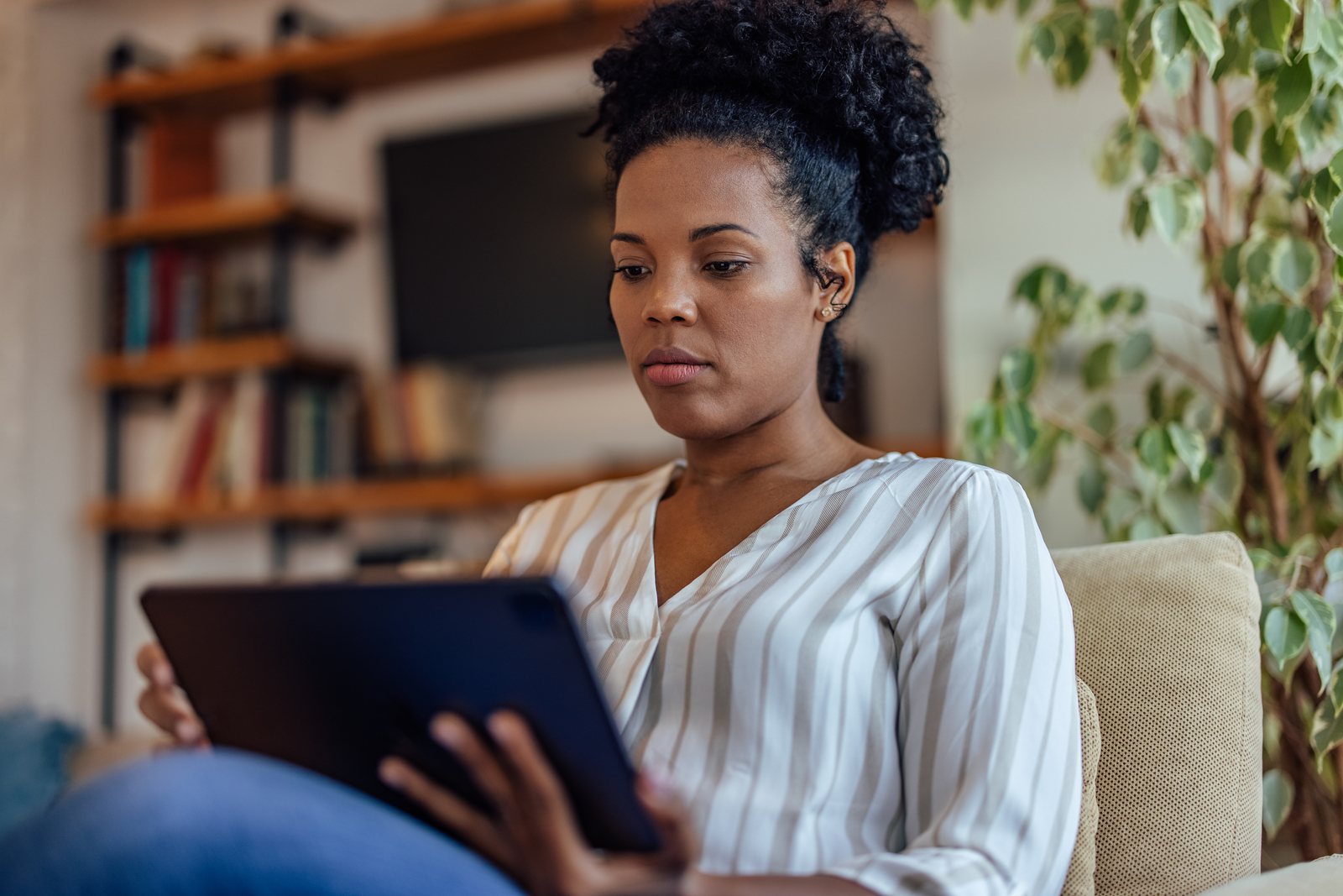 Dame utilisant sa tablette électronique à la maison.