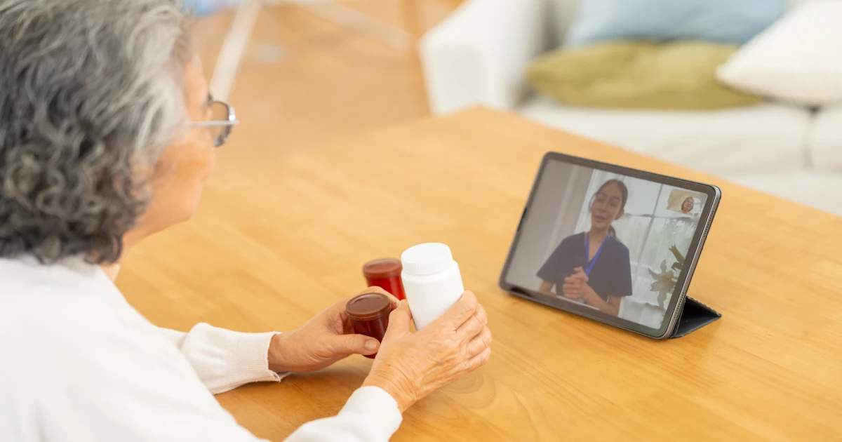 Dame qui discute de chez elle avec une infirmière en utilisant une tablette